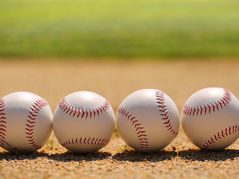 four baseballs on the ground
